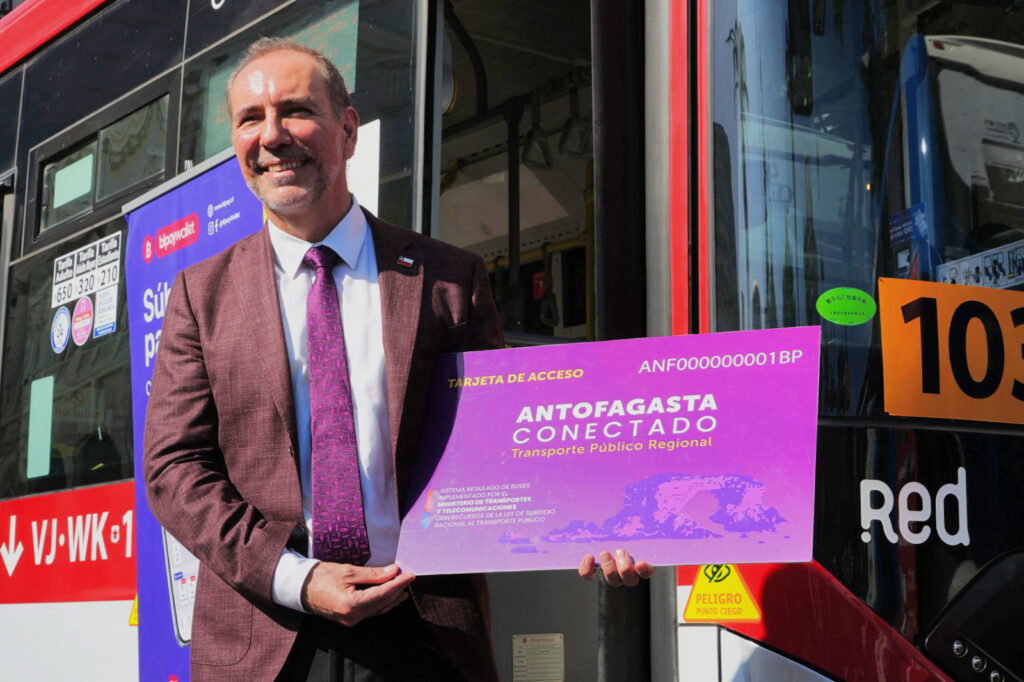 Ministro de Transportes y Telecomunicaciones Louis de Grange sosteniendo tarjeta